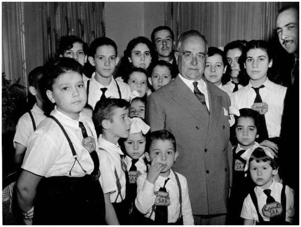 Fotografia de Getúlio Vargas entre crianças.